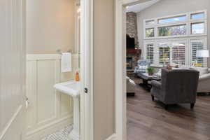 Bathroom with lofted ceiling, hardwood / wood-style floors, and a stone fireplace