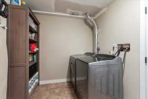 Laundry area featuring a textured ceiling and washing machine and dryer