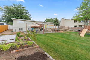 Back of property with a lawn, a patio, a deck, and a playground