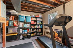 Workout room featuring electric panel and concrete floors