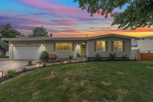 Single story home with a garage and a yard