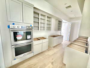 Kitchen with light hardwood / wood-style floors and stainless steel double oven