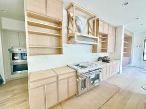 Kitchen featuring stainless steel appliances, light brown cabinets, and light wood-type flooring