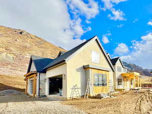 Rear view of house featuring a garage and a mountain view