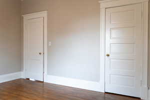 Unfurnished bedroom featuring dark wood-type flooring