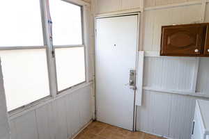 Doorway featuring wood walls