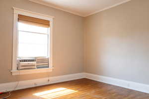 Spare room featuring hardwood / wood-style flooring and crown molding