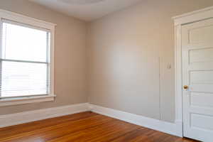 Unfurnished room featuring a wealth of natural light and wood-type flooring