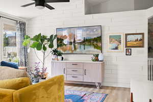 Living area featuring light wood-type flooring, vaulted ceiling, and ceiling fan