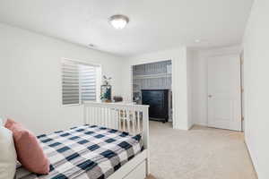 Carpeted bedroom featuring a fireplace