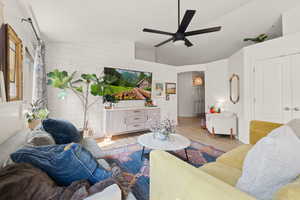 Living room featuring vaulted ceiling, light wood-type flooring, and ceiling fan