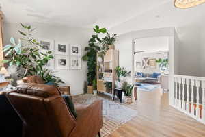 Living room with vaulted ceiling and light wood-type flooring