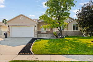 View of front of home with a garage and a front lawn