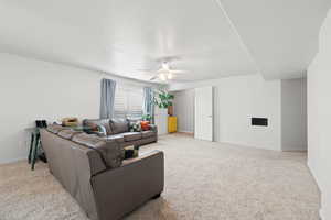 Carpeted living room with ceiling fan