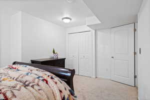 Bedroom with light colored carpet and a closet