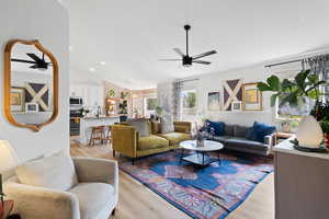 Living room with vaulted ceiling, sink, ceiling fan, and light hardwood / wood-style floors