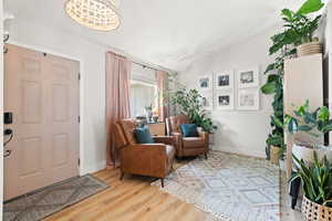 Foyer entrance with vaulted ceiling and light hardwood / wood-style flooring