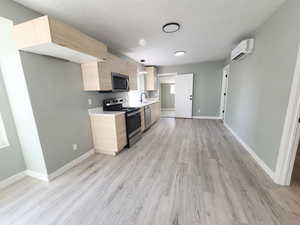 Sleek, updated kitchen with stainless steel appliances, quartz countertops and laminate flooring