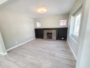 Spacious, light-filled living room with a cozy fireplace and laminate flooring