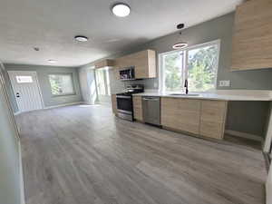 Kitchen featuring appliances with stainless steel finishes, large windows, and ample counter space