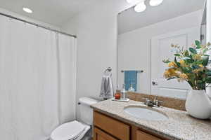 Hall Bathroom with vanity, toilet, and walk in shower