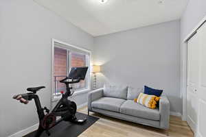 Bedroom with a textured ceiling and light hardwood / wood-style flooring