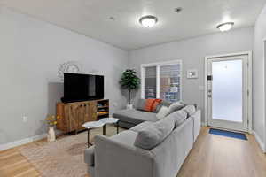 Living room featuring a textured ceiling and light hardwood / wood-style flooring