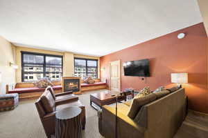 Carpeted living room featuring a textured ceiling