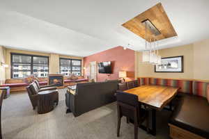 Dining space featuring a raised ceiling and carpet flooring