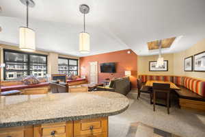 Kitchen featuring hanging light fixtures and carpet