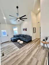 Living room with light wood-type flooring, vaulted ceiling, and ceiling fan