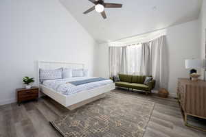 Bedroom featuring high vaulted ceiling, hardwood / wood-style floors, and ceiling fan