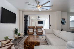 Living room with ceiling fan and a textured ceiling