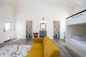 Living room with high vaulted ceiling and wood-type flooring