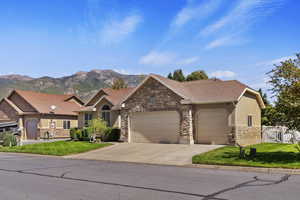 View of front facade featuring a mountain view, a front yard, and a garage