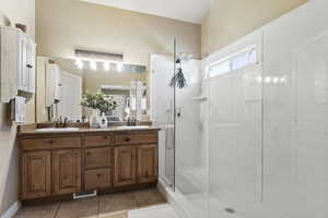 Bathroom featuring vanity, tile patterned floors, and a shower with shower door