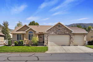 Single story home with a front yard, a mountain view, and a garage