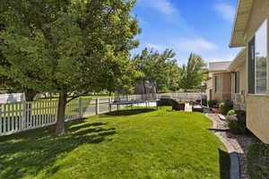 View of yard with a trampoline and a patio