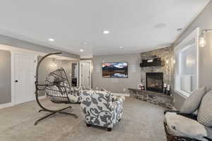 Living room featuring carpet floors and a stone fireplace