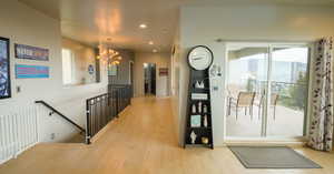 Corridor featuring a notable chandelier and light wood-type flooring