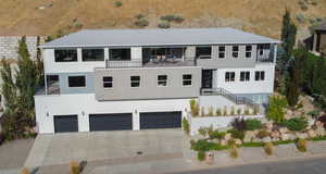 View of front of home with a garage and a balcony