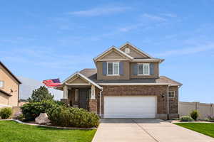 View of front facade featuring a garage and a front lawn