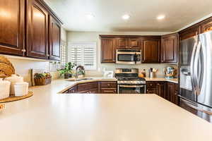 Kitchen with appliances with stainless steel finishes, a textured ceiling, and sink