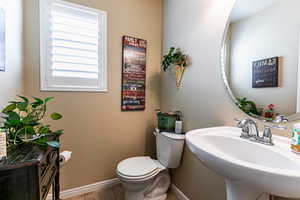 Bathroom featuring toilet, sink, and tile patterned floors