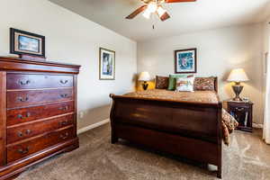 Carpeted bedroom with ceiling fan