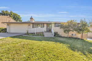 Single story home with a garage and a front yard