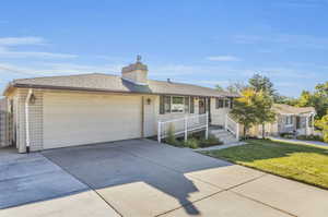 Ranch-style home featuring a garage and a front yard