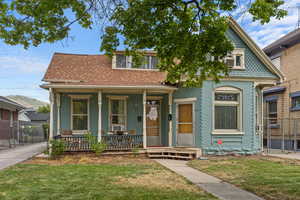 View of front of home with covered porch and a front yard