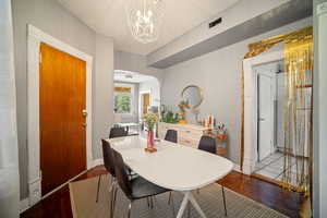 Dining area with dark hardwood / wood-style floors, a notable chandelier, and a textured ceiling