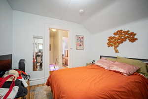 Bedroom with lofted ceiling and hardwood / wood-style floors